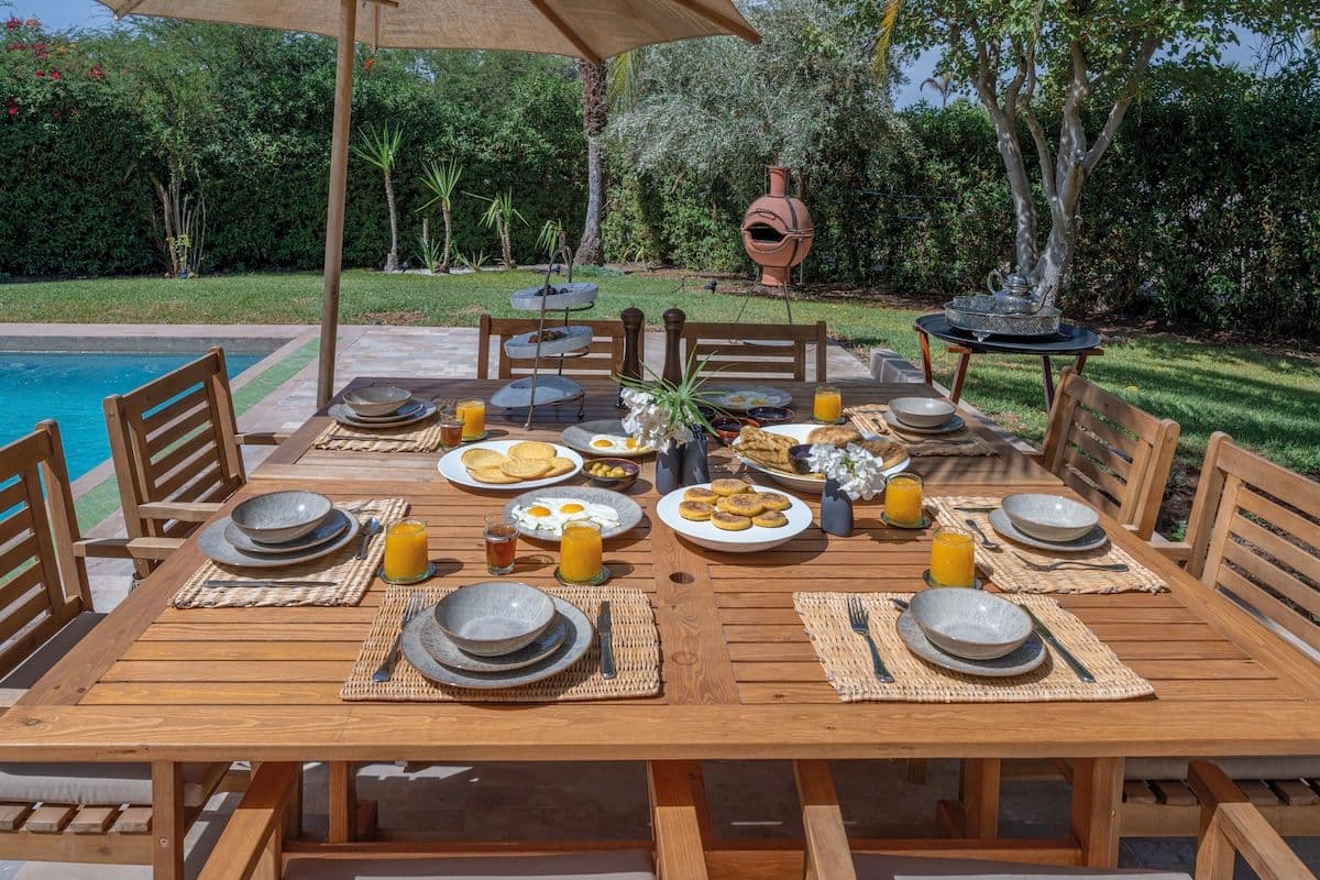 Petit-déjeuner dressé au bord de la piscine Villa Aima Marrakech